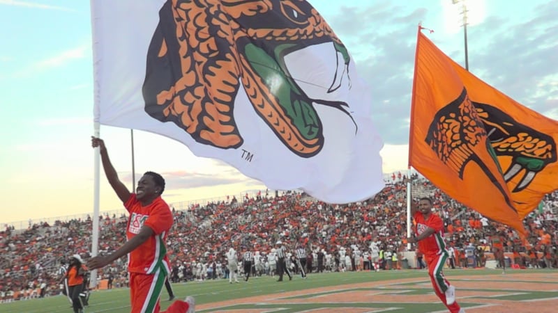Florida A&M Rattlers cheerleaders carry flags at Bragg Memorial Stadium
